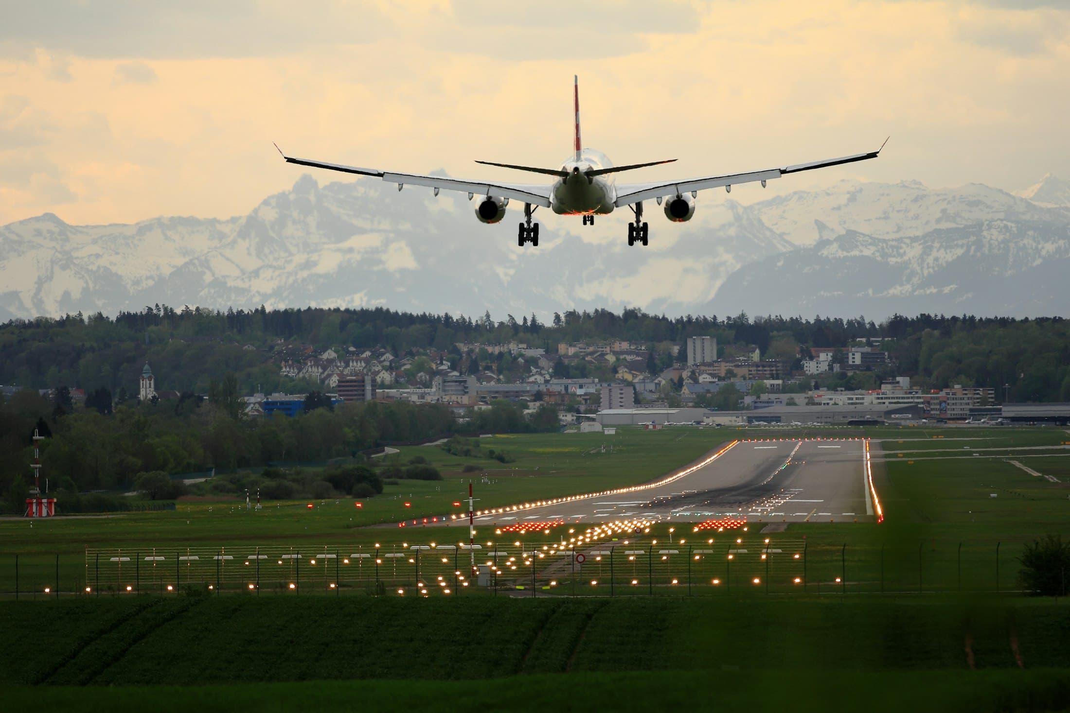 Airliner on final approach over the runway at dusk