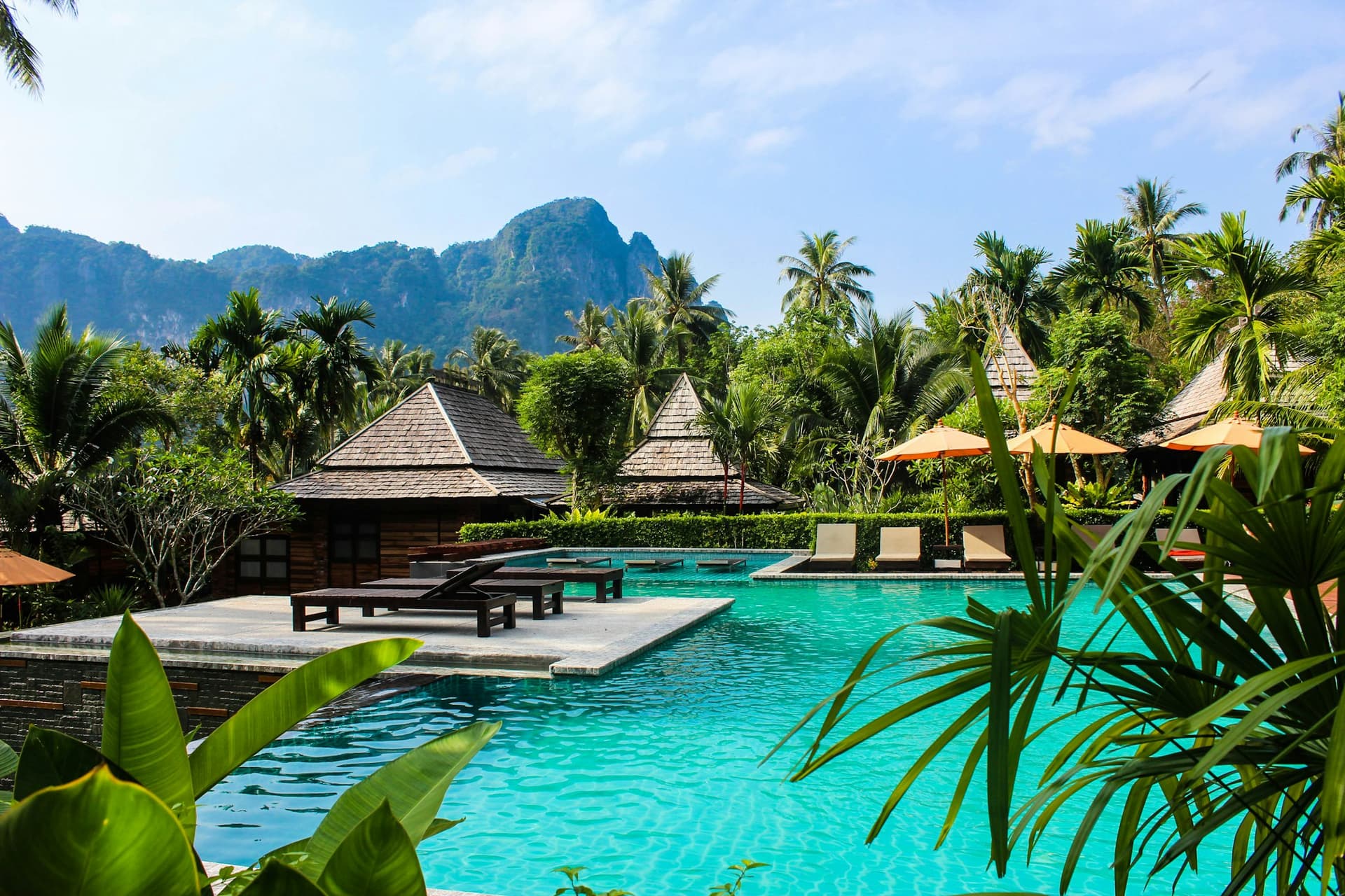 Resort pool surrounded by palms and limestone hills
